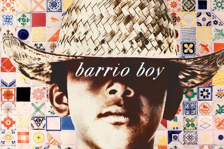 Cover of the book "Barrio Boy" featuring a young boy in front of a colorful background with a hat covering his eyes