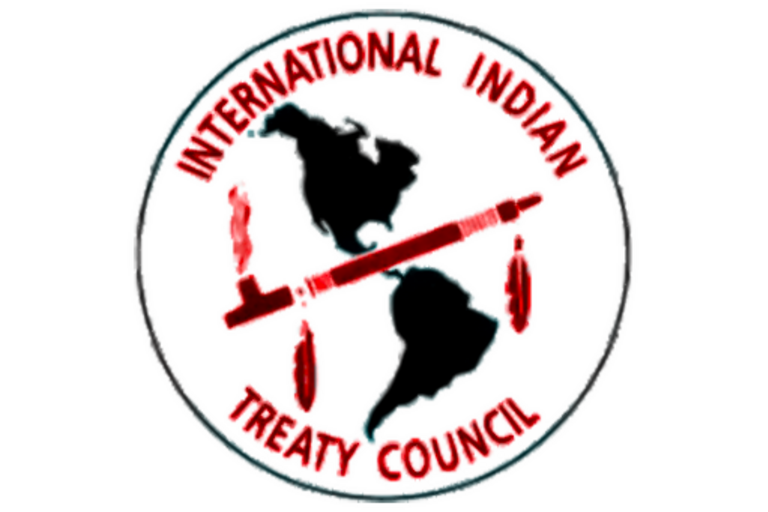 A logo for the International Indian Treaty Council that contains a map and a pipe