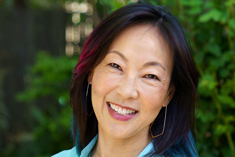 Headshot of SanSan Kwan outdoors with trees in background 