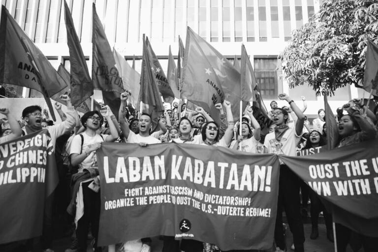 Members of Anakbayan-USA at a protest holding a banner that says "Laban Kabataan"